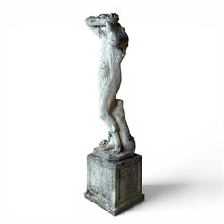 Weathered cast stone garden statue of a 'Shy Maiden', raised on square plinth base