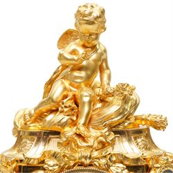 Charpentier & Cie-French 8-day mantle clock c 1860, in an ormolu case with Sevres style plaques, fluted pedestal case decorated with acanthus leaves and floral swags, surmounted by a putto and raised on toupie feet, convex enamel dial with Roman numerals, minute track and five-minute Arabic's, with makers name and Louis XVI style gilt hands, Parisian twin train movement with rack striking, sounding the hours and half-hours on a bell. With pendulum and key.
Charpentier & Cie, operated in Paris from around 1830 to 1860. They are especially well-known for their clock and garniture sets, as well as for their works of bronze. With pendulum and key.

