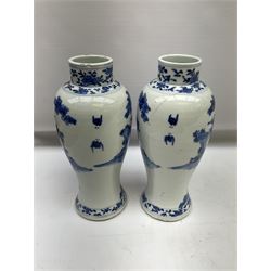 Pair of later 19th century Chinese blue and white vases and covers of baluster form, decorated with figures in a garden setting, with flower and foliate decoration to the neck, the covers with foo dog finials, with six character mark within double concentric circle beneath, H28cm