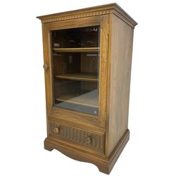 Ercol - mid-20th century dark elm 'Old Colonial' music cabinet, single glazed door enclosing three shelves, single drawer fitted to base