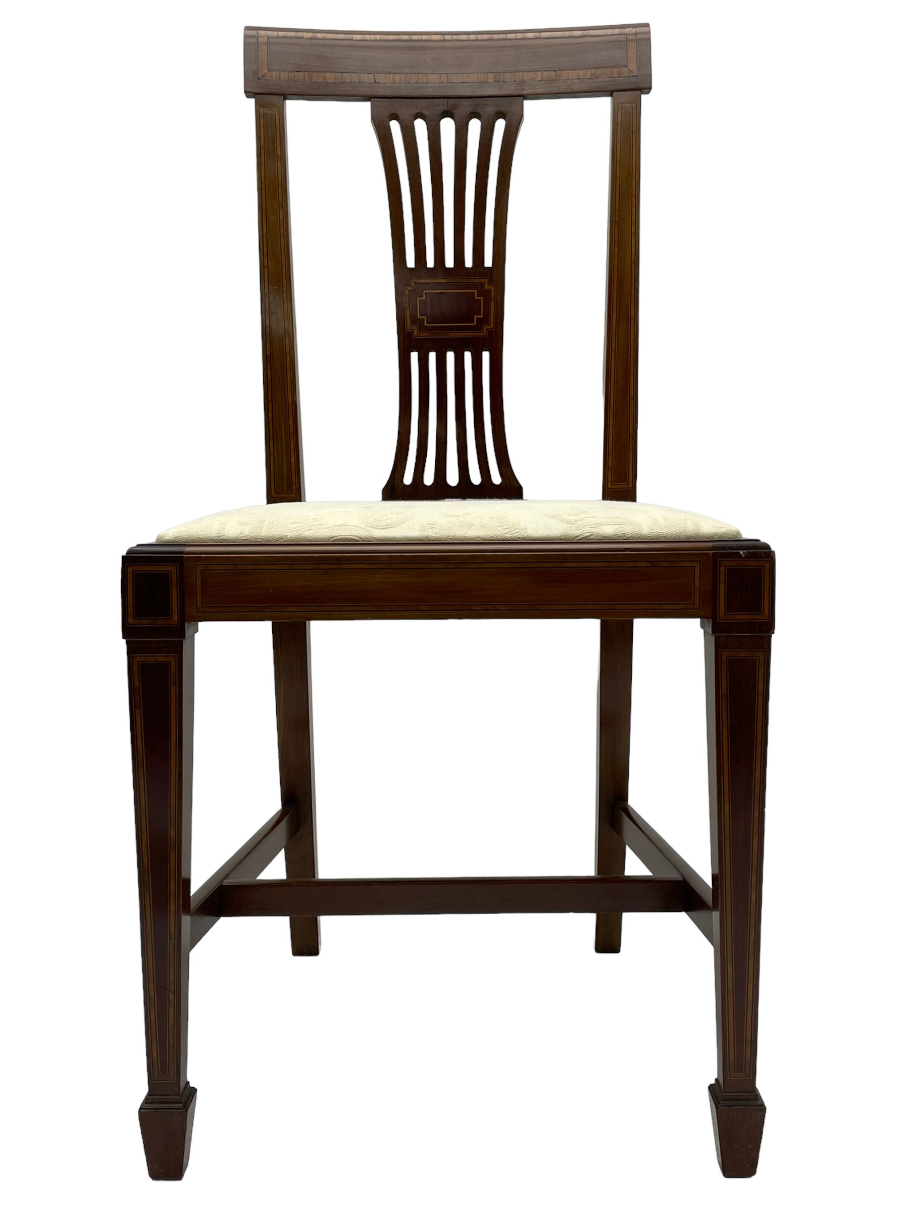Set twelve (4+8) Edwardian inlaid mahogany dining chairs, cresting rail with satinwood banding, pierced splat backs with central inlay, drop-in seats upholstered in foliate patterned ivory fabric, raised on square tapering supports terminating in spade feet