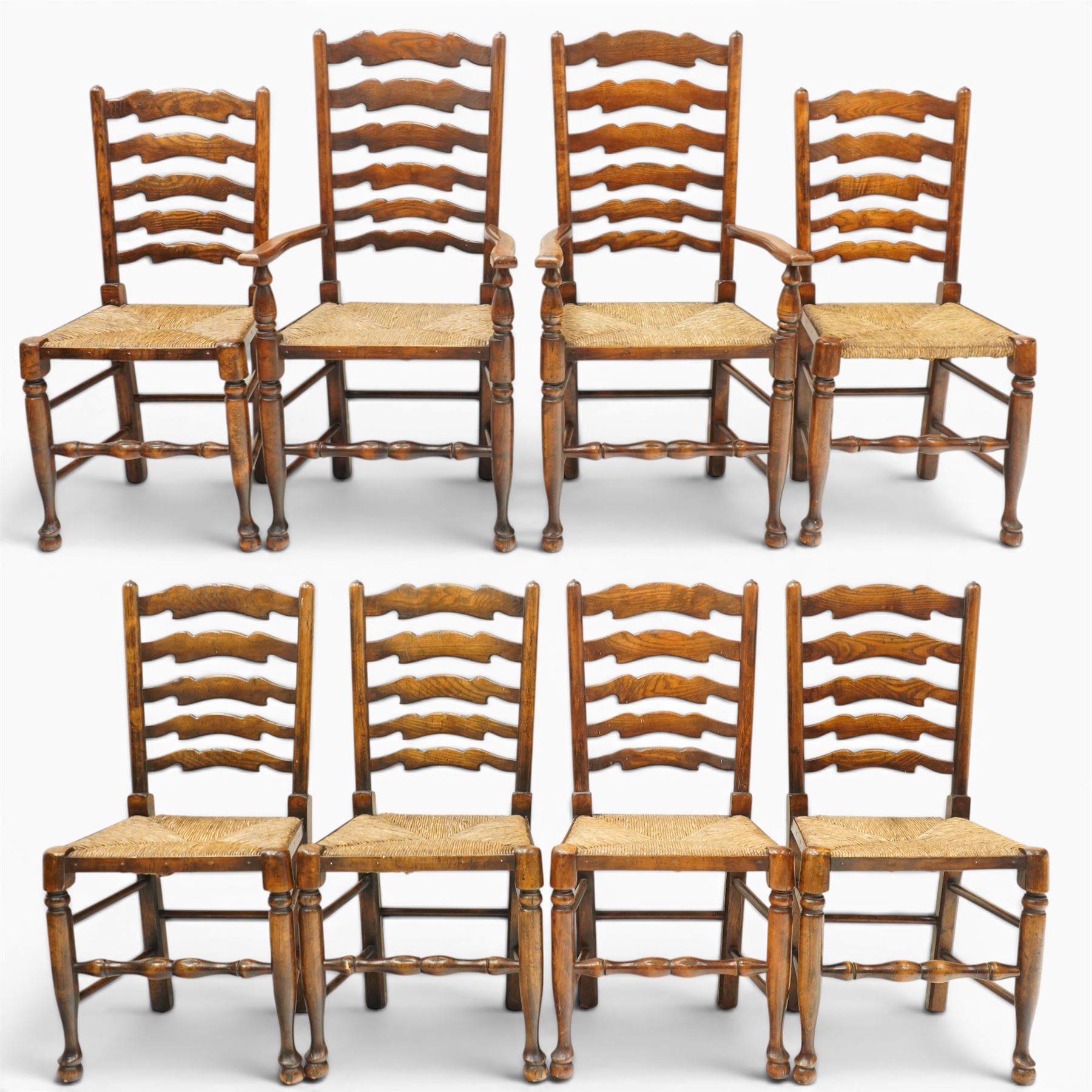 Set of eight country ladderback chairs (6+2), shaped ladderback over a rush seat, raised on turned supports, united by stretchers