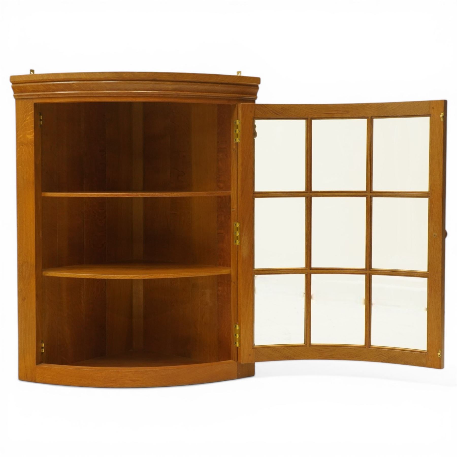 Beaverman - oak hanging corner cabinet, astragal glazed door with a Yorkshire Rose door pull, revealing two fixed shelves, brass mounts for hanging, with carved beaver signature, by Colin Almack of Sutton near Thirsk