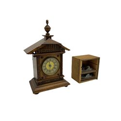 A German musical alarm clock (model 1523/24) made by the Hamburg Amerikanische Uhrenfabrik c1880, in an oak case with an architectural top and finial, two-part dial with a gilt centre, ivorine chapter and steel spade hands, with roman numerals and minute track, case raised on four bun feet, with a thirty-hour balance wheel pin pallet spring driven movement sounding the alarm on a musical movement, key wound and set from the rear. Compete with three different and changeable musical movements in their original box. These clocks would have been sold as here with separate musical movements, it is rare to find them with the original clock.
H30 W17 D11 

	



