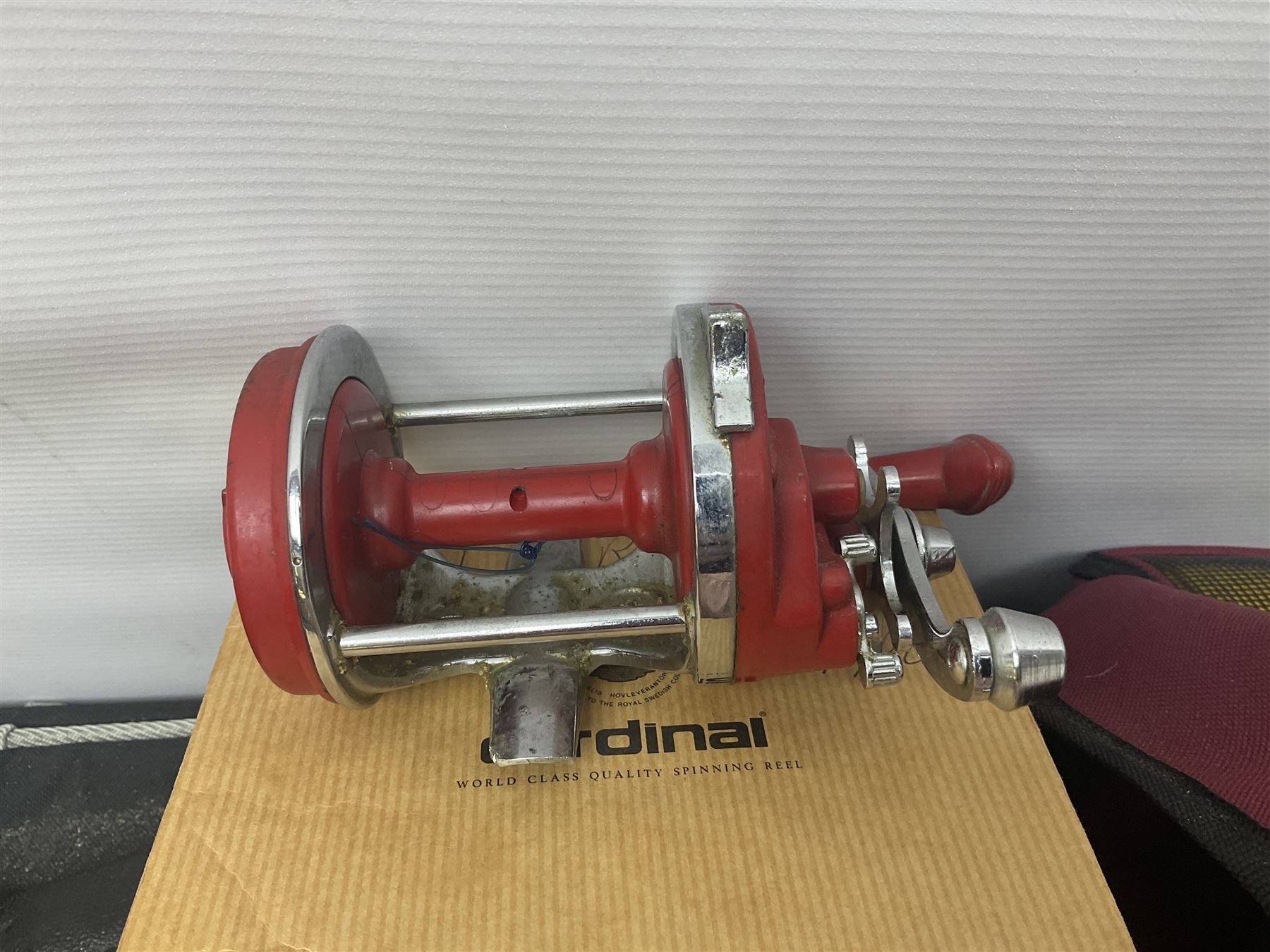 Collection of fishing memorabillia and equipment, including an Allcocks three piece split cane trout fly rod, Shakespeare Salt 3600 surf rod, two tackle bags, Old Red Seastreak multiplier reel, Sportext Saltwater fixed spool reel, fishing dvds, etc