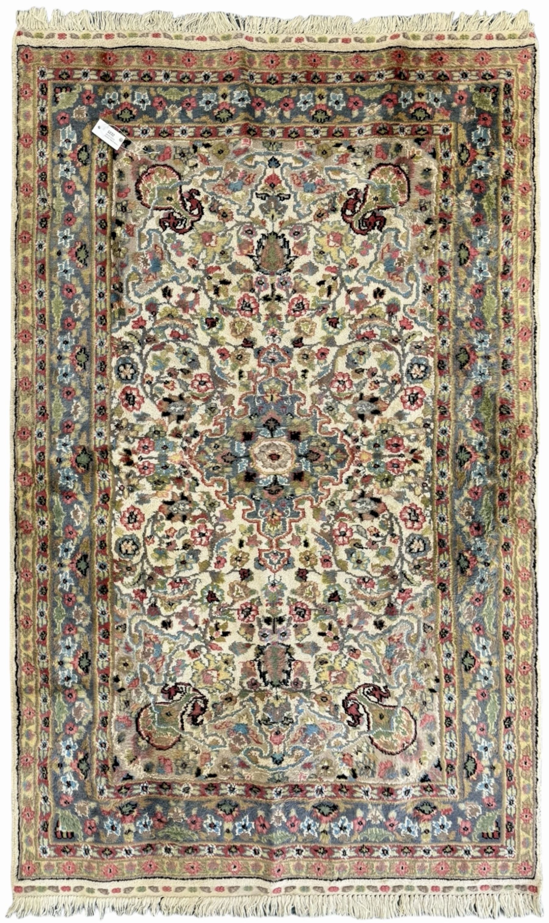 Persian design ivory ground rug, overall floral design with shaped central medallion, the main border decorated with trailing flower head pattern, within guard stipes 
