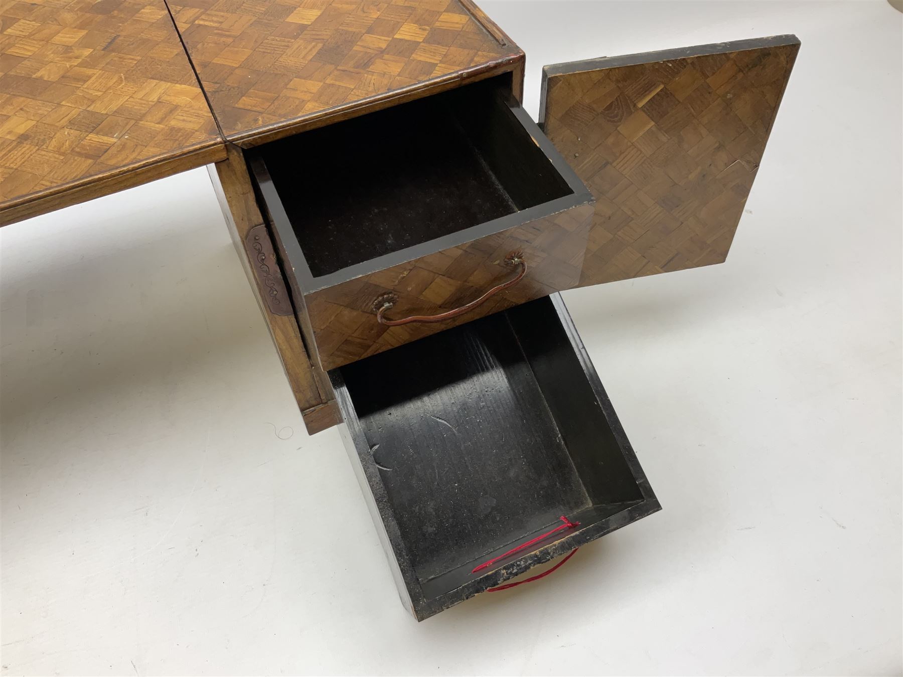 Japanese miniature kneehole desk decorated with parquetry inlay, the loose leaf top resting on one pedestal cabinet with four drawers, and another with hinged cupboard door opening to reveal two interior drawers above a lower drawer, H26cm, W68.5cm D24cm
