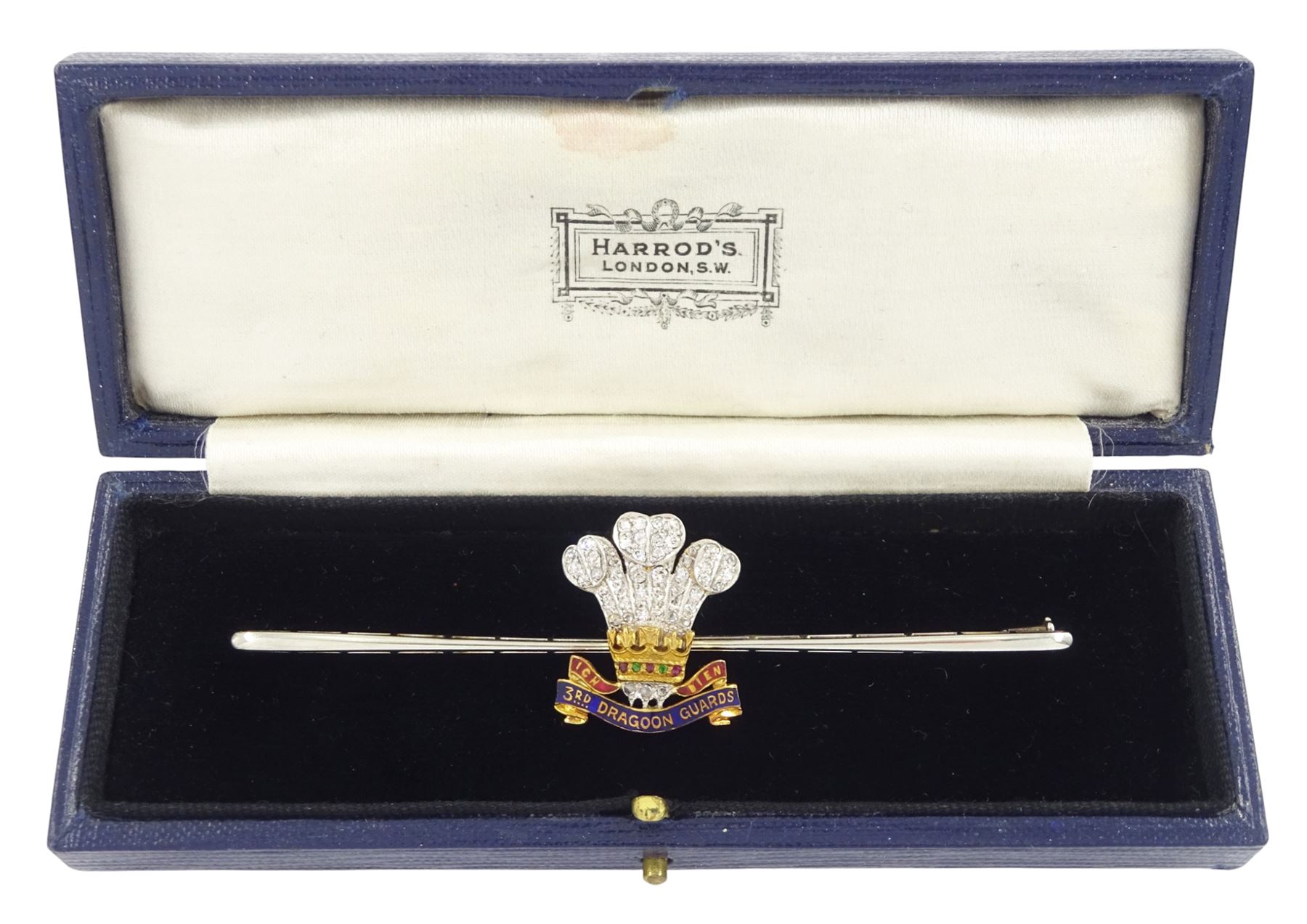 Early 20th century gold and palladium 3rd Dragoon Guards, multi gemstone set brooch, the Prince of Wales crest set with old cut and rose cut diamond ostrich feathers, garnet and ruby coronet and enamelled logo, in silk and velvet lined case by Harrods of London 