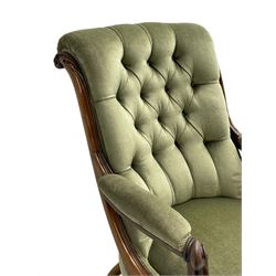 Early Victorian walnut framed gentleman's open armchair, scroll back and arms over a serpentine fronted seat, the frame decorated with carved applied acanthus leaves and S-scrolls, upholstered in button back laurel green fabric with sprung seat, raised on cartouche carved cabriole supports with brass castors