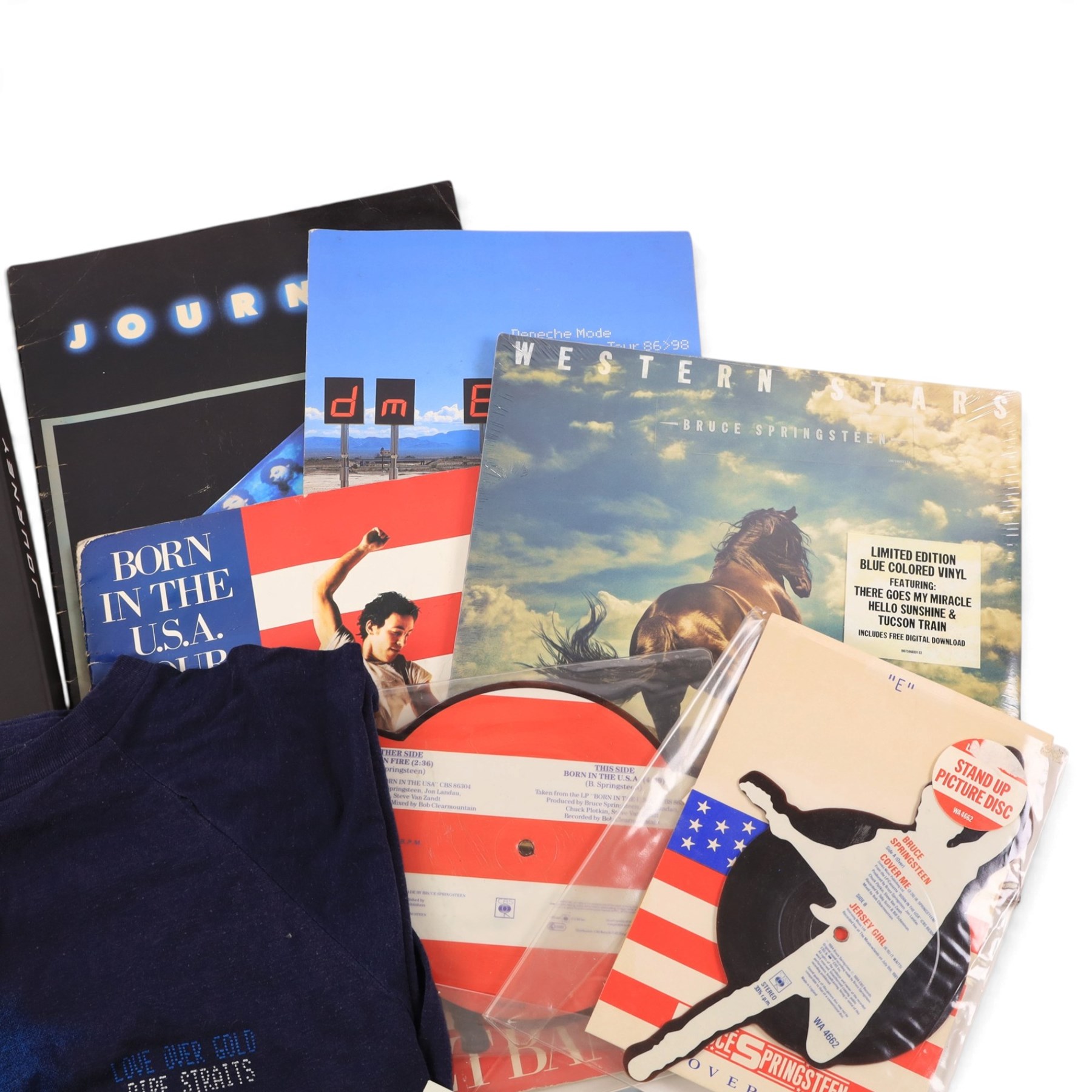 Collection of 1980s and later music tour merchandise and records, including Dire Straits Love Over Gold t-shirt, U2 Zooropa t-shirt, Bruce Springsteen Born In The USA tour programme, Bruce Springsteen Cover Me Stand Up picture disc and sleeve, Bruce Springsteen Born In The USA picture disc, Bruce Springsteen Western Stars limited edition coloured vinyl, Depeche Mode Singles Tour programme 1986-88, Journey 1986 programme and ticket stub, Journey Eclipse Collectors Edition Set and 2017 Download Festival passes