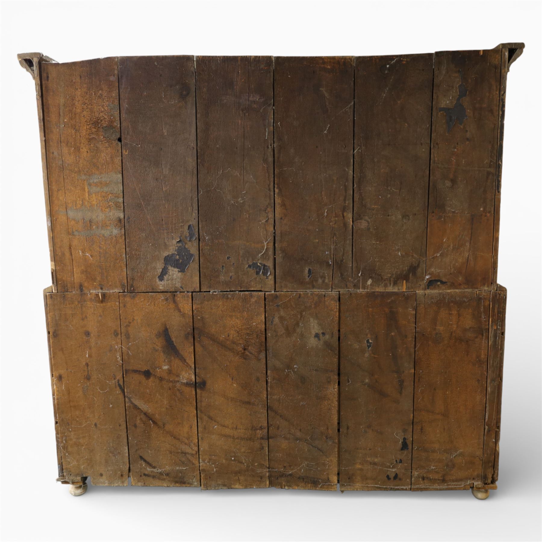 Large Victorian stripped pine reverse breakfront housekeeper’s cupboard, the moulded cornice above a central pair of panelled cupboard doors flanked by single cupboard doors and divided by turned baluster pilasters, the lower section fitted with an arrangement of twelve drawers with knob handles, raised upon bun feet