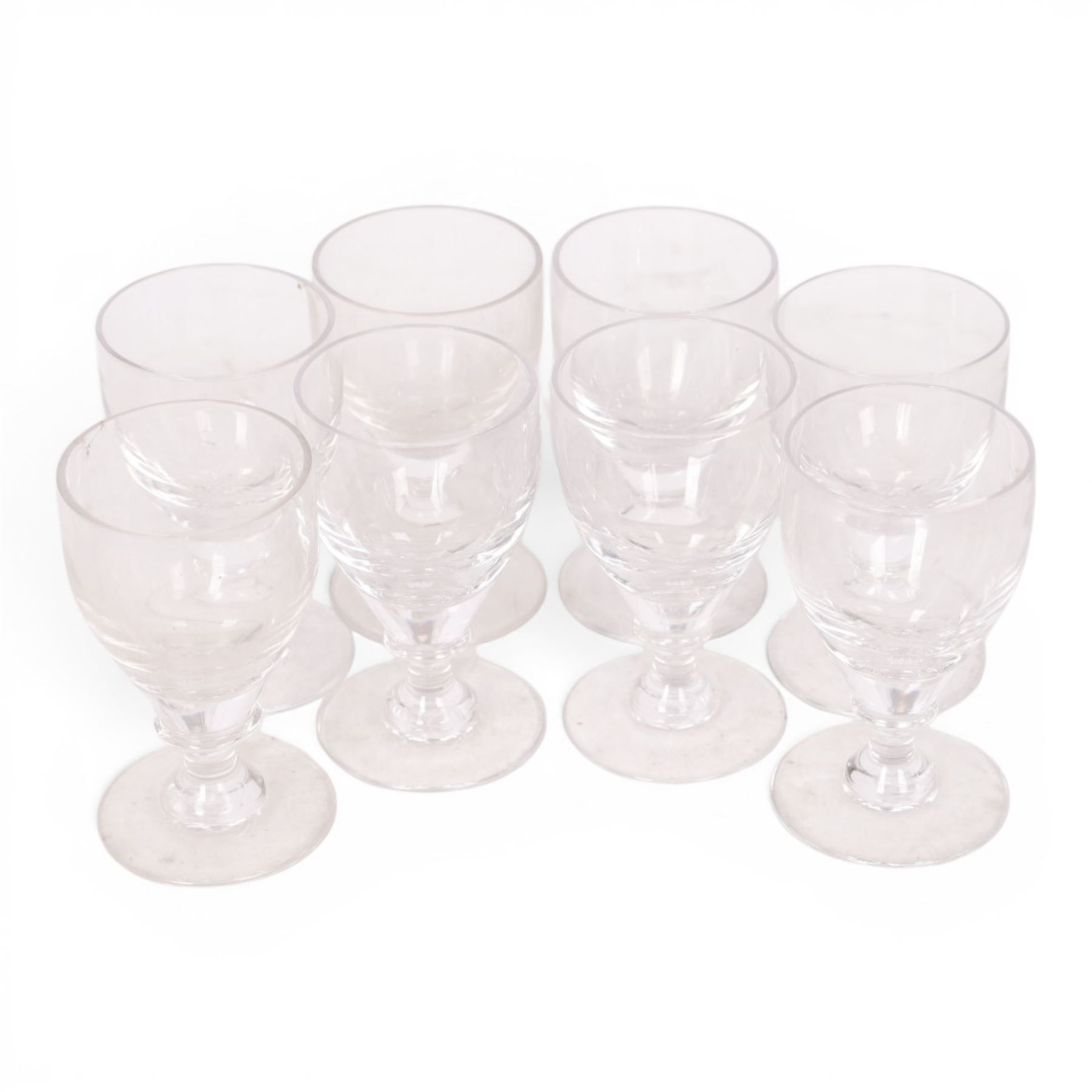 Georgian shaped drinking glasses, comprising eleven larger, H12.5cm, and eight smaller, H10.5cm, each with ovoid bowl upon knopped stem and circular foot