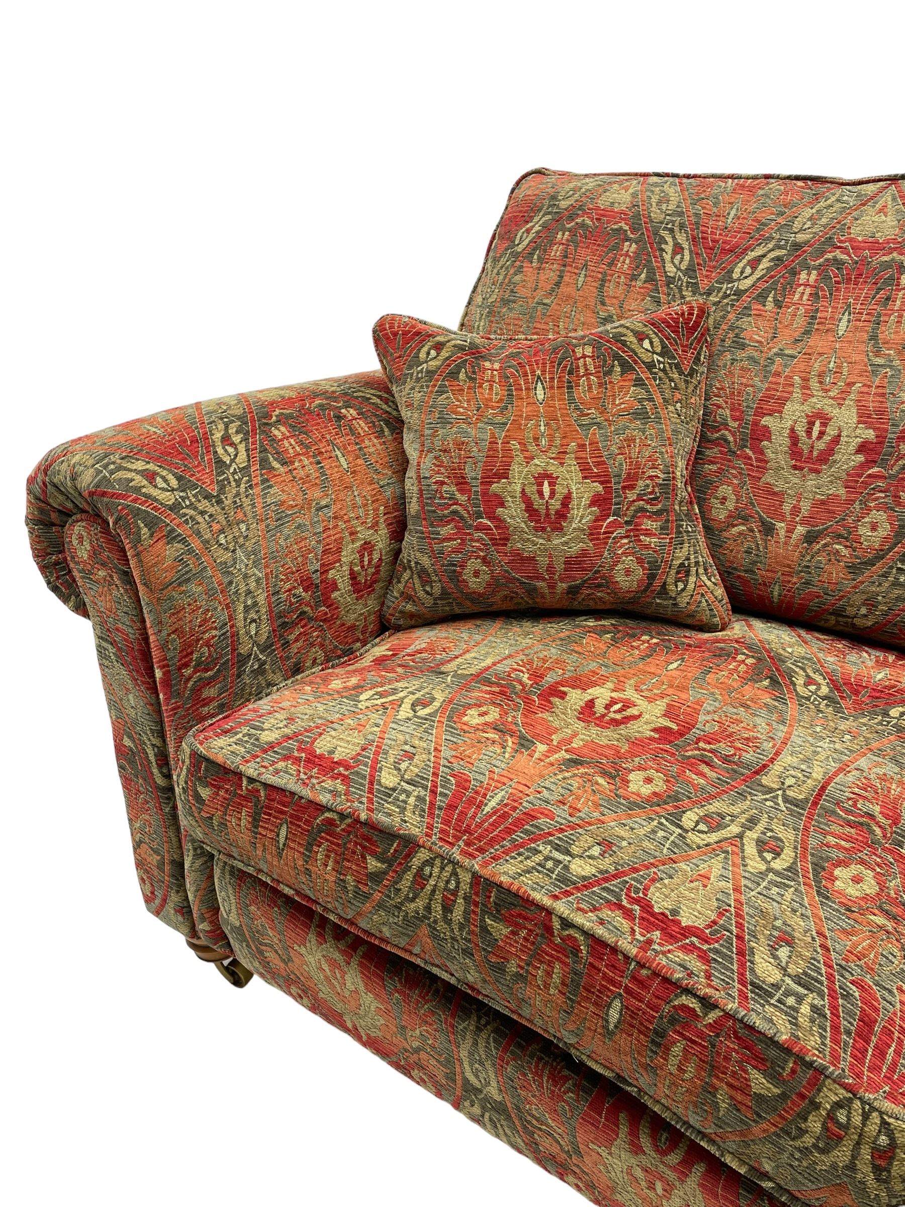 Duresta - 'Beaminster' grande two-seat sofa, traditional shape with rolled arms, upholstered in 'Althorp' russet and stone floral pattern fabric, on turned feet with brass castors
