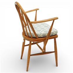 Ercol - elm dining chairs, a set of five comprising four side chairs and one '370' armchair, all with hoop backs formed with slender spindle splats, shaped solid elm seats, the armchair with curved out-swept arms, raised on splayed turned supports united by stretchers