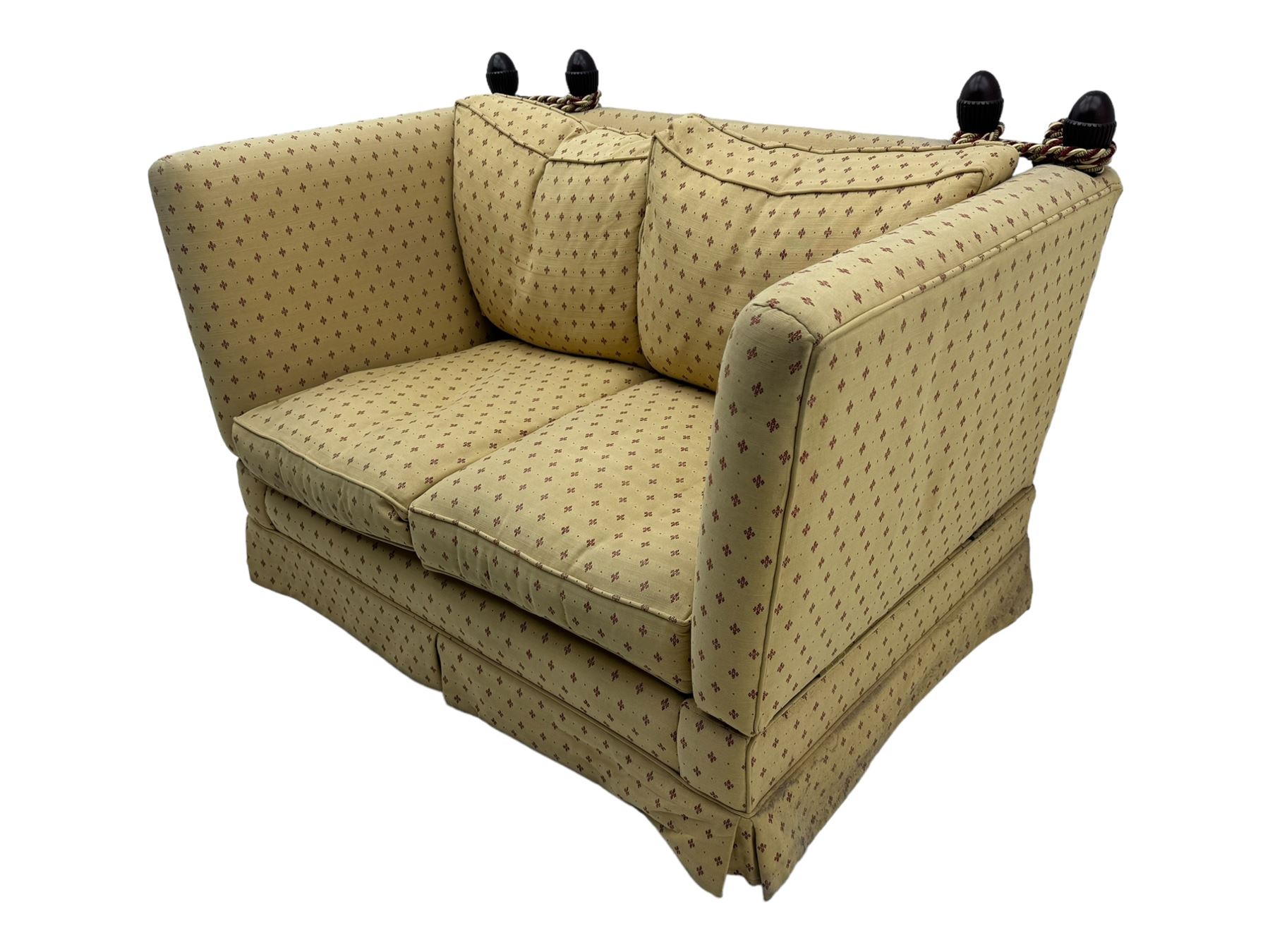 20th century Knole design two seat sofa, high back and double drop-arm joined by mahogany finials and ties, upholstered in camel ground fabric with red lozenge design, on turned supports with brass castors