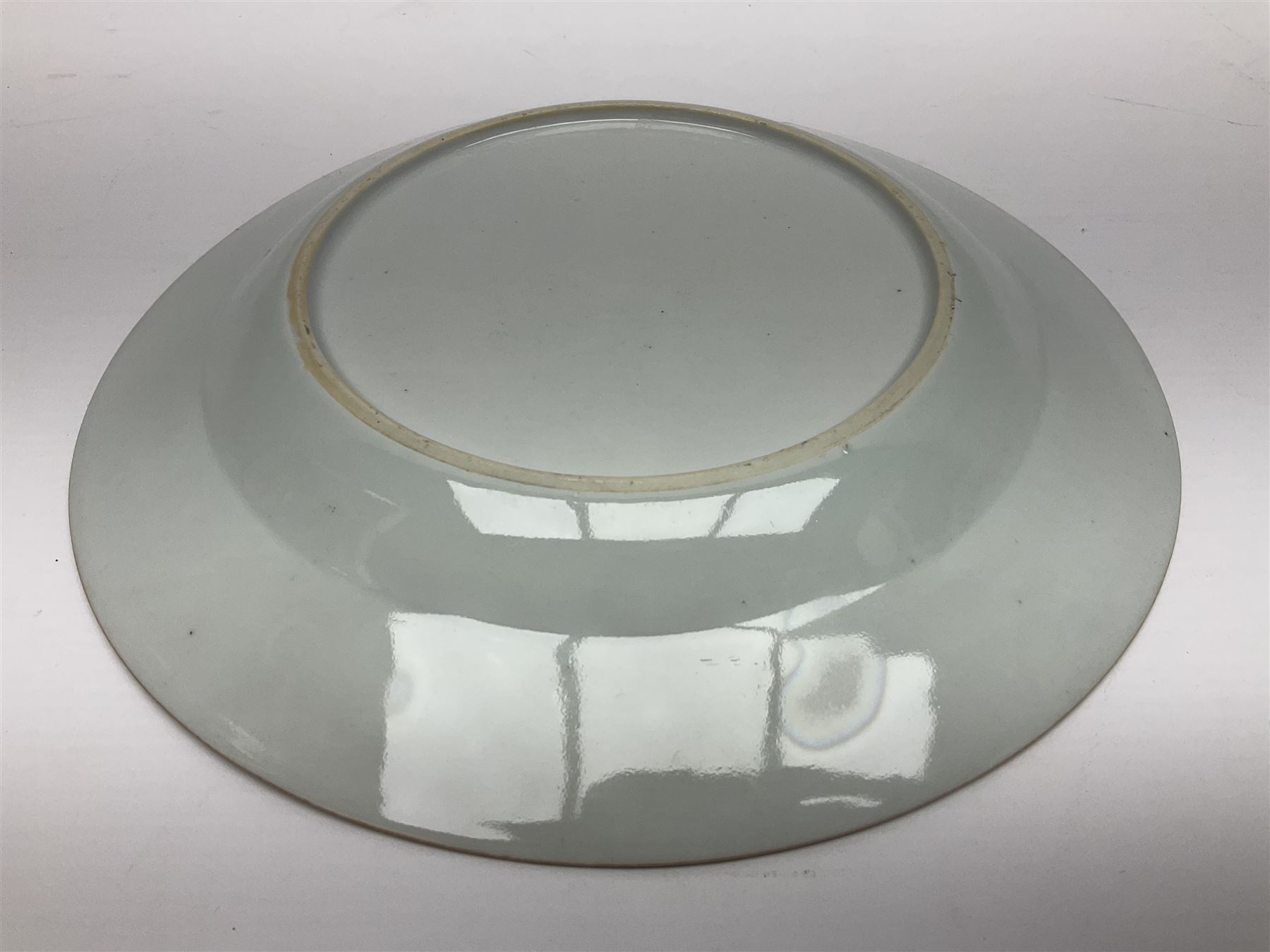 Three 18th century Chinese Famille Rose plates, the first example enamelled with blossoming peonies, rockwork and fence, the other two examples of similar design, decorated with blossoming peonies and sprigs within shaped inner borders, each approximately D23cm