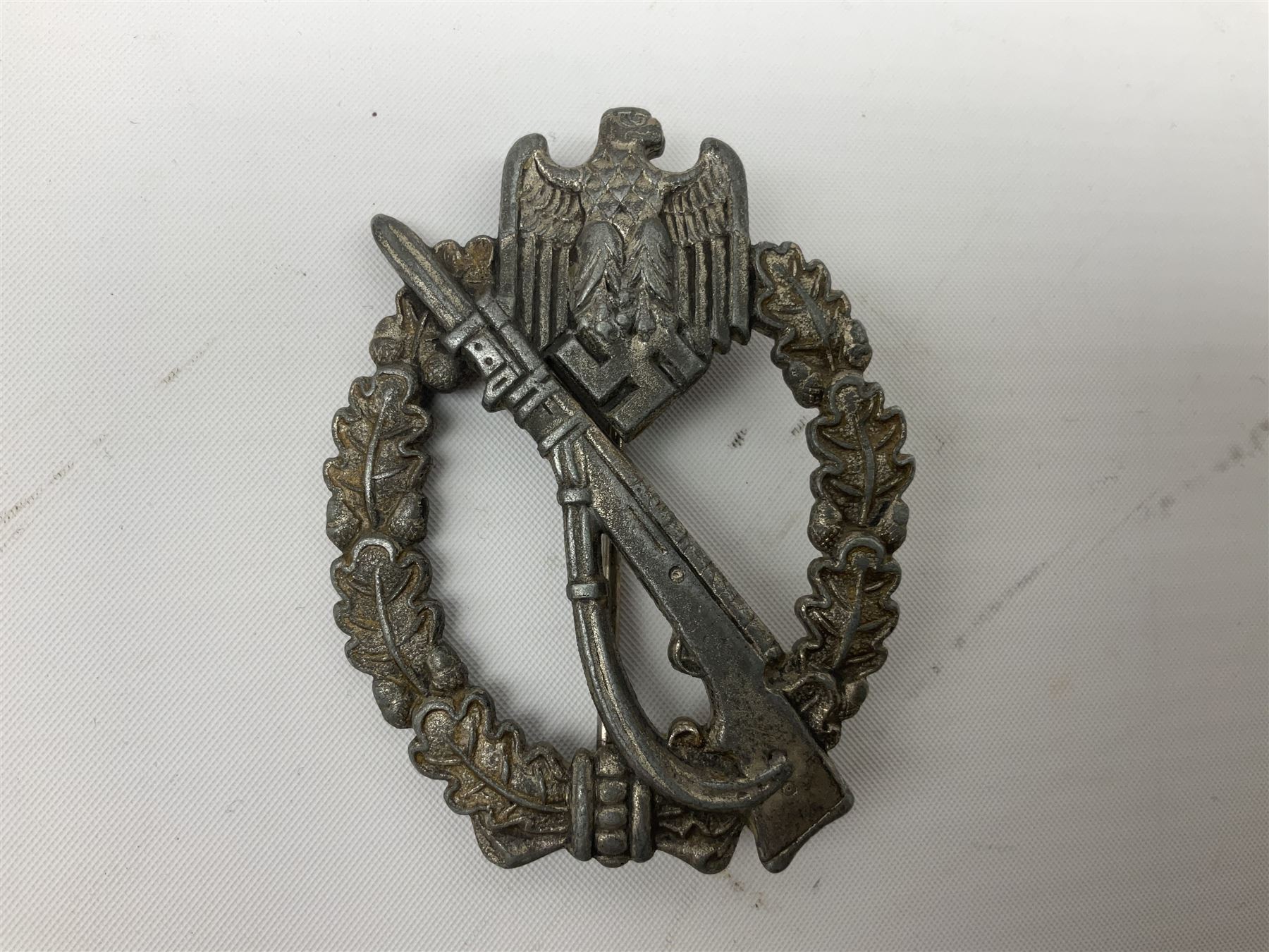Three WW2 German badges comprising Blockade Runner War Badge and Coastal Artillery badge, both marked 'Fec Otto Placzec Berlin'; and Infantry Assault Badge; all with fixing pins (3)