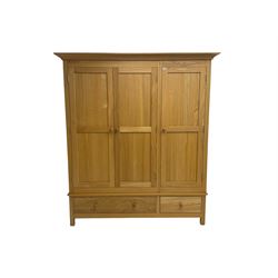 Light ash triple wardrobe, enclosed by three panelled doors, the base fitted with two drawers