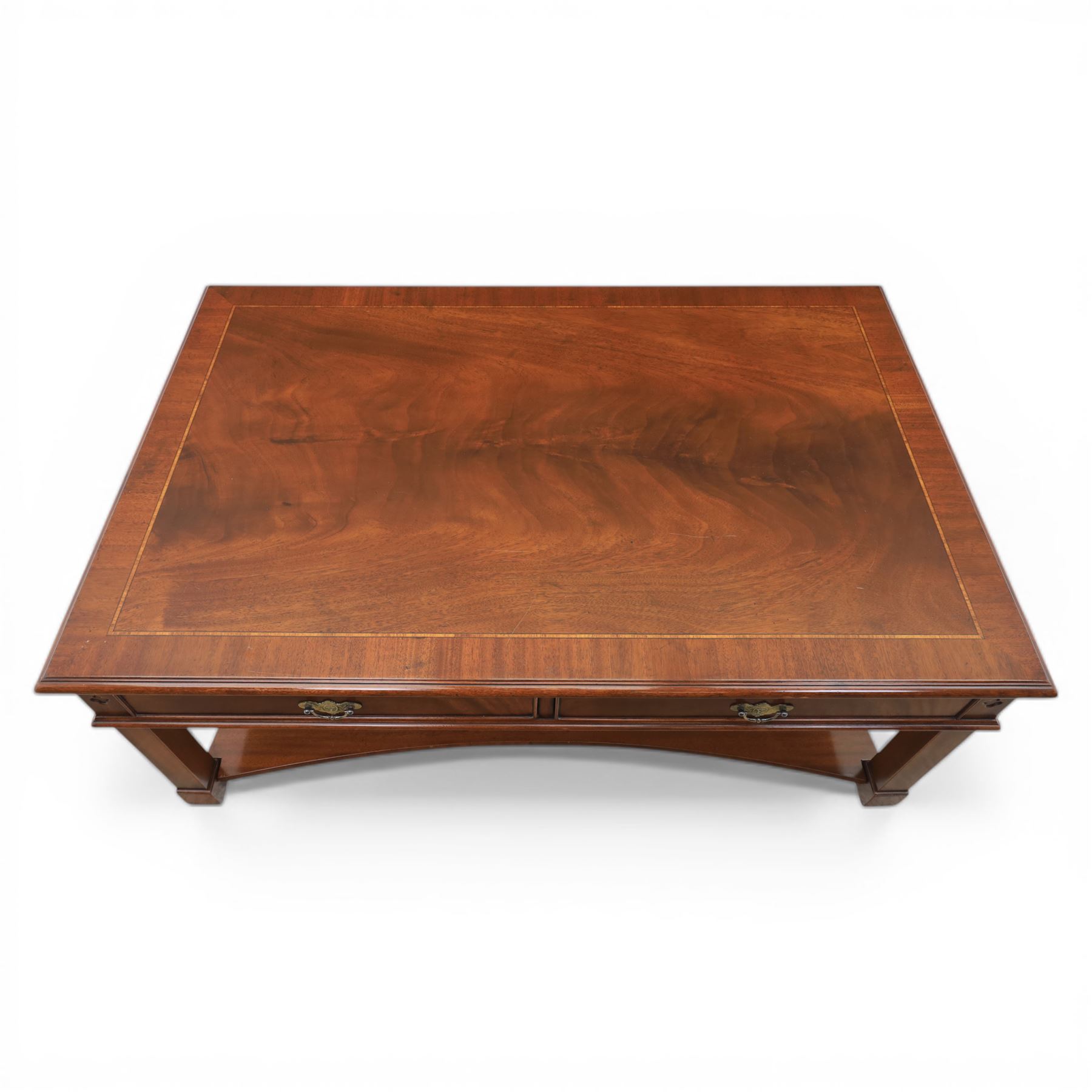 Georgian style mahogany coffee table, rectangular moulded top with crossbanded border and line inlay, fitted with two cock-beaded frieze drawers with ornate brass swan neck handles and shaped backplates, opposing false drawer fronts, raised on square tapering supports united by a concave undertier