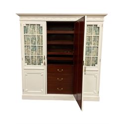 Maple and Co - Edwardian Hepplewhite design white painted triple wardrobe, foliate carved projecting cornice over ribbon and husk swag decorated frieze, two curtain lined astragal glazed doors and centre full mirror door, fitted mahogany interior including slides and drawers, plinth base, label to top of central door