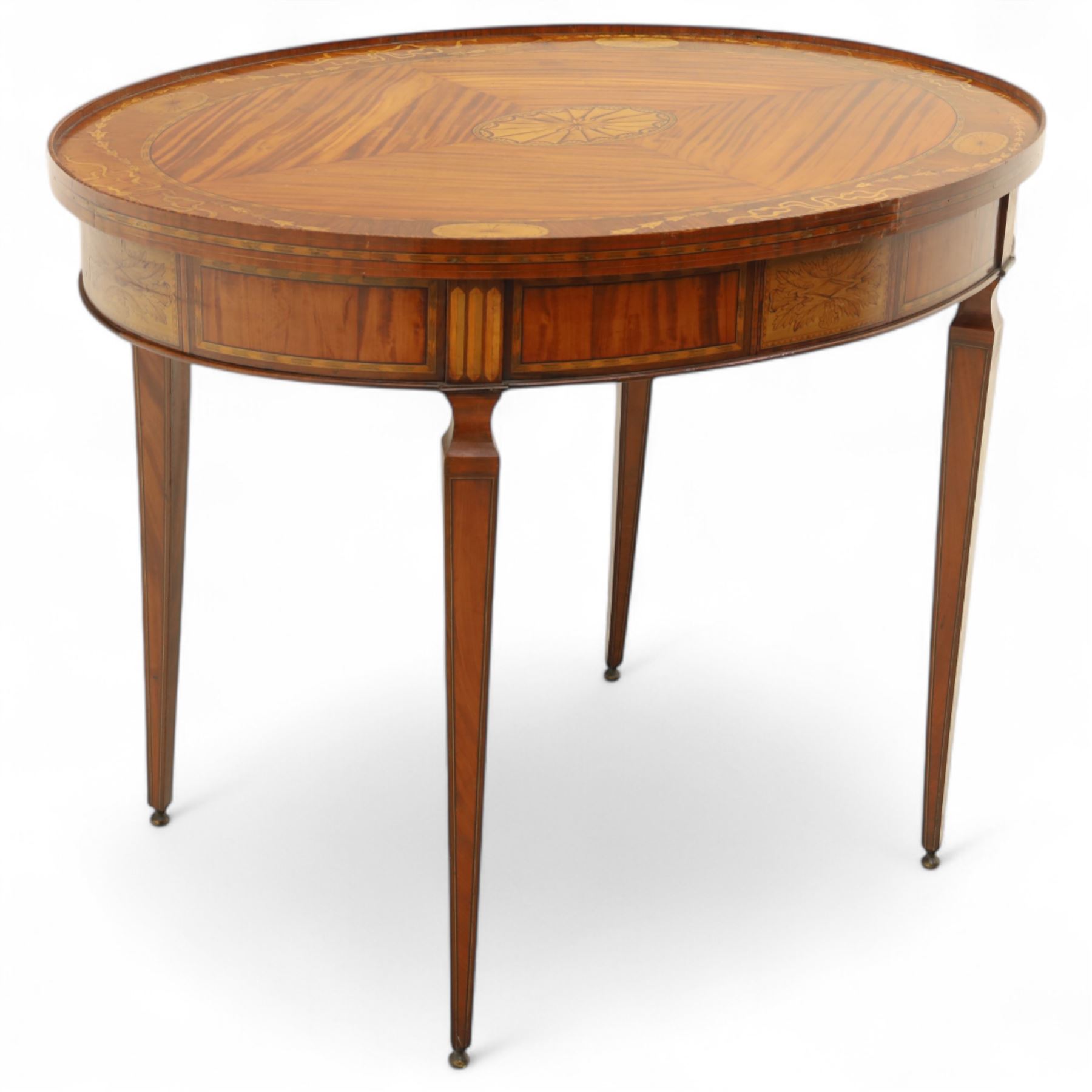 Aldam Heaton & Co (fl.1878-97) - late 19th century Sheraton revival style satinwood inlaid oval centre table, raised inlaid edge, centre with finely executed large central  inlaid medallion, surrounded by ribbon tied swags interspaced with medallions, frieze with rectangular symmetrical panels of foliate sprays of acanthus leaves, raised on four square section tapering legs with cavetti shaped shoulders with stringing on brass bulb feet, underside with bone plaque signed Aldam Heaton & Co, Baker St, London