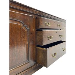 George III oak dresser base, rectangular top with rounded corners over moulded frieze rail, canted corners with turned quarter columns, fitted with three drawers with moulded edges flanked by two cupboards, enclosed by ogee arched fielded panelled doors, panelled sides, moulded plinth base