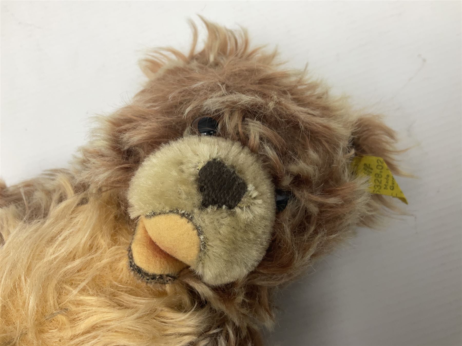 Steiff teddy bear with golden plush body, revolving head, applied eyes, vertically stitched nose and mouth and jointed limbs; button to left ear H26cm; and two other Steiff teddy bears, each with open mouth and button with tag to left ear (3)
