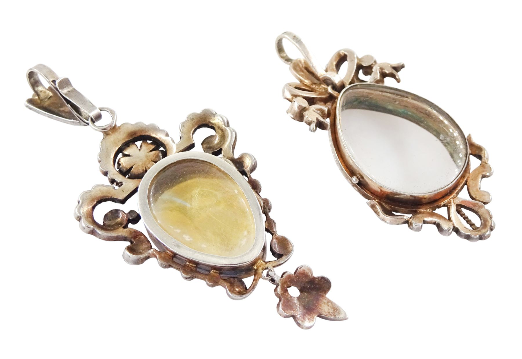 Two 19th century French silver pearl locket pendants, the first set with a pear shaped portrait miniature of a woman in 18th century dress on ivory, within a milled bezel and openwork split and seed pearl surround, the other of similar design with ribbon surmount and set with garnets and seed pearls, both hallmarked. This lot has been registered for sale under Section 10 of the APHA Ivory Act