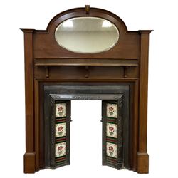 Early to mid-20th century mahogany fire surround, stepped arched top with oval bevelled mirror, fitted with shelf with fluted frieze, together with an early to mid-20th century metal fire inset with tiled uprights