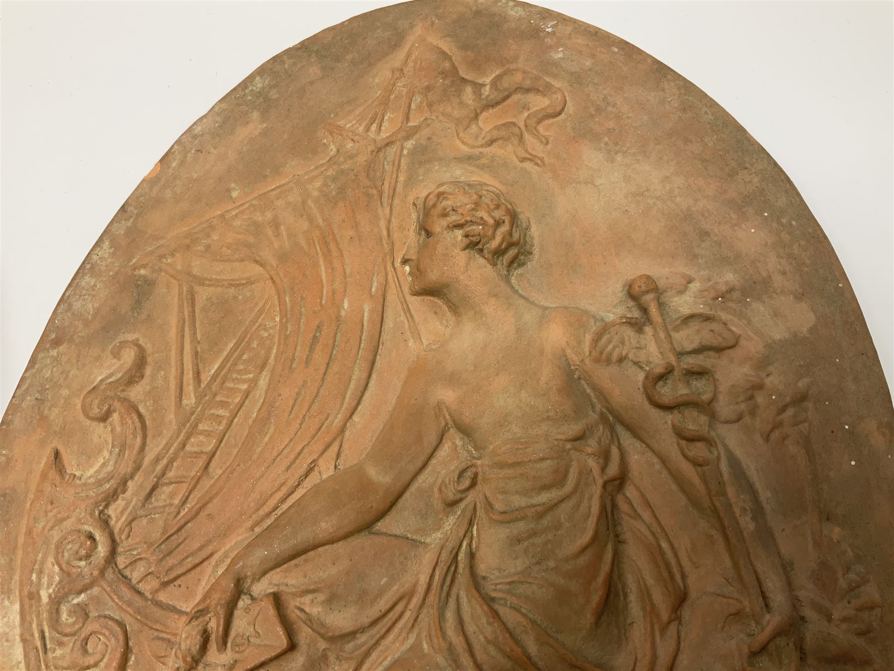 Pair of 19th century classical terracotta relief wall plaques depicting the goddess Hygeia and another goddess, seated holding an ewer, each of oval form, indistinctly signed, each stamped Ferreira verso, H42cm, W30cm