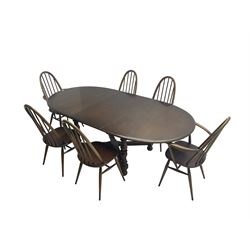 Ercol - 'Old Colonial' 705 elm extending dining table, oval top with hidden leaf, raised on turned supports united by X-stretcher (W163cm D108cm H72cm); and Ercol - set six  (4+2) dark elm 'Quaker Back Windsor Dining Chairs', hoop and stick backs 