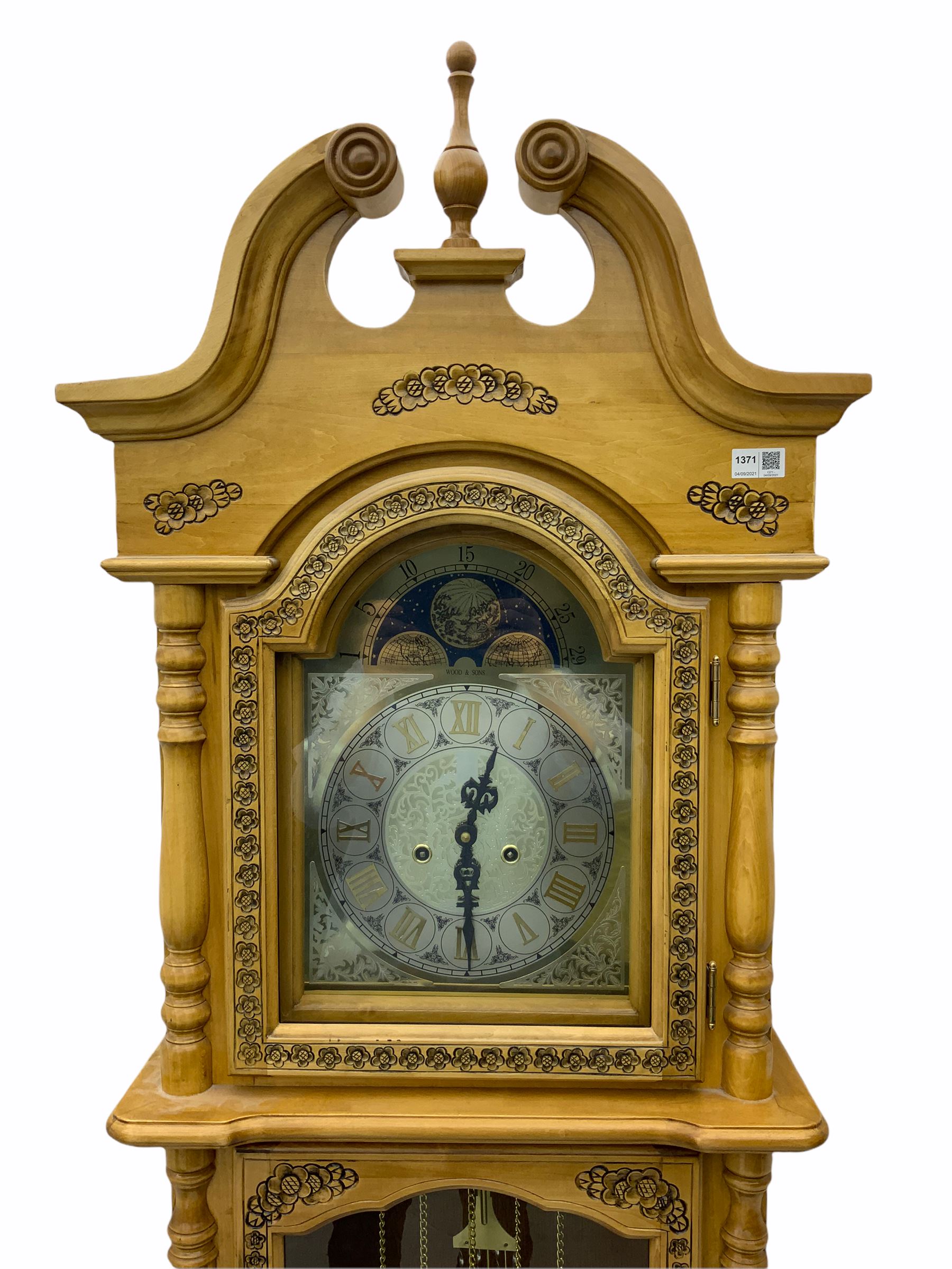 21st century replica longcase clock by “Wood & Son” in a incised light wood case with a swans neck pediment and finial, turned columns flanking a glazed broken arch hood door, trunk with a full length glazed door on a short stepped plinth, visible lyre pendulum with dummy chains and weights, 31 day going barrel movement striking the hours and half hours, brass and silver effect dial with roman numerals and decorative steel hands, faux (non- working) moon dial to the arch.