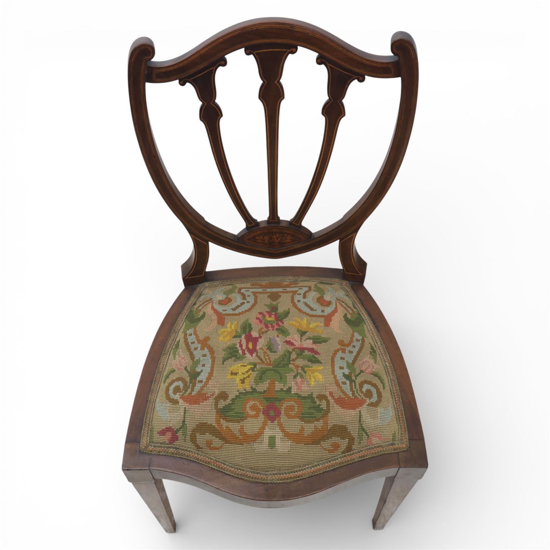 Edwardian pair of satinwood inlaid shield back chairs, the pierced shield shaped backs with central splats inlaid with floral and foliate motifs, tapestry upholstered serpentine seats, raised on square tapering supports