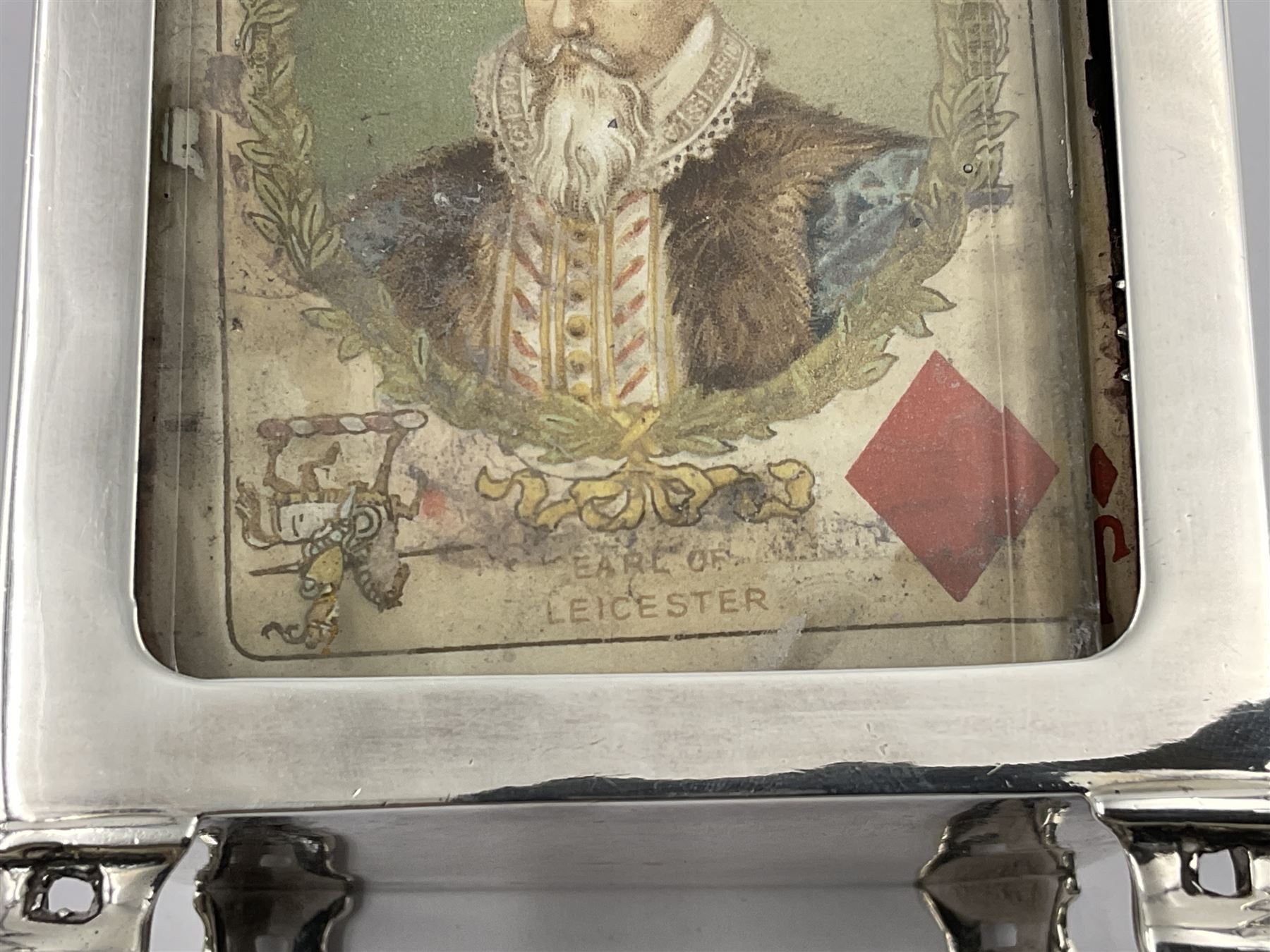 Edwardian silver mounted playing card case, hallmarked William Harrison Walter, Birmingham 1903, the sides each with a period playing card set behind a bevelled glass panel, the hinged cover with later engraving 'Presented to Norman T Crombie Esq by the officers & men of the 31st WR Detachment for services rendered 1917-1918', with red leather lined interior, the three compartments upon a sprung base and containing two later wooden Whist markers, case H12.5cm