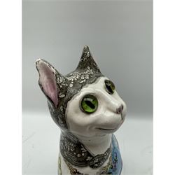 Émile Gallé (French 1846-1904): Faience model of a cat, naturalistically modelled, the head inset with green marbled glass eyes, glazed and painted with flowers on blue ground, the neck decorated with a pendant brooch bearing a portrait of a dog, signed beneath H34cm