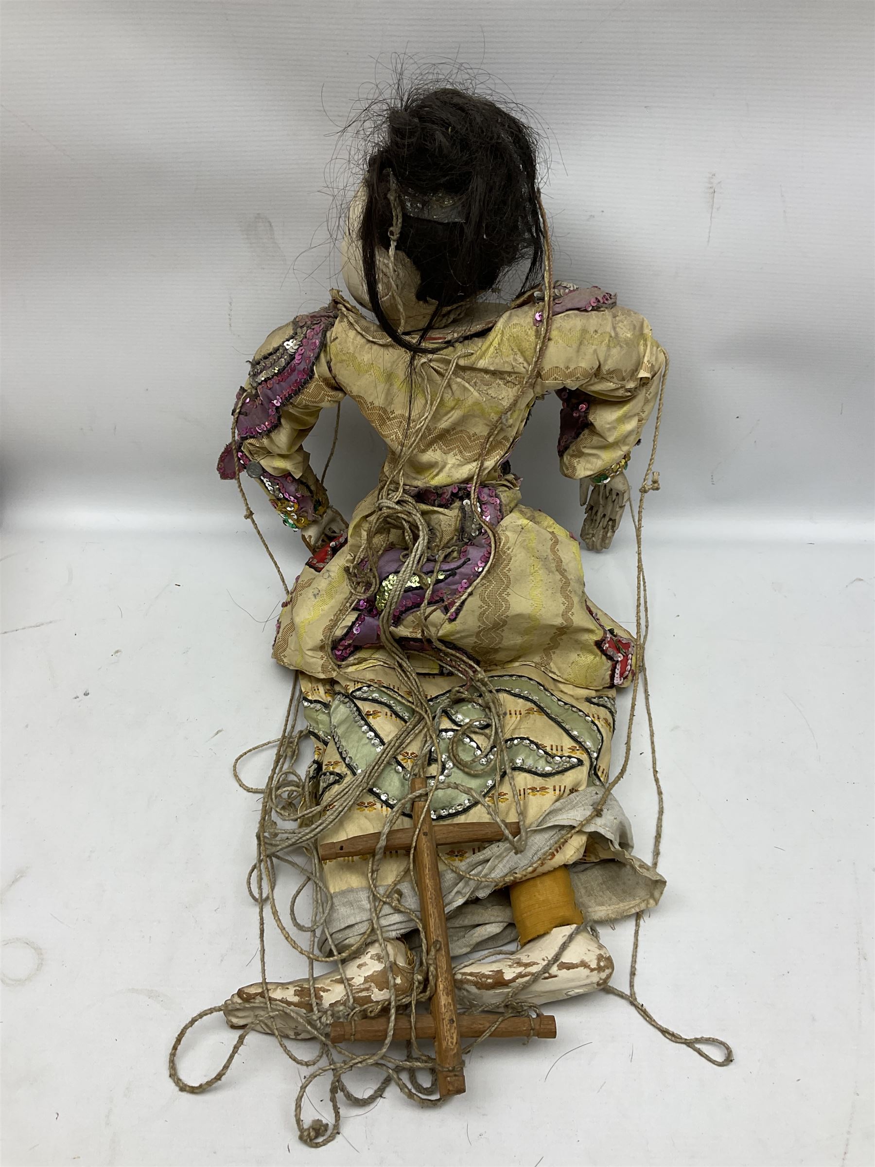 Large string puppet, probably Thai or Burmese, modelled as a woman in traditional costume embellished with sequins, the painted head with articulated mouth, the wood body and hands jointed, L70cm