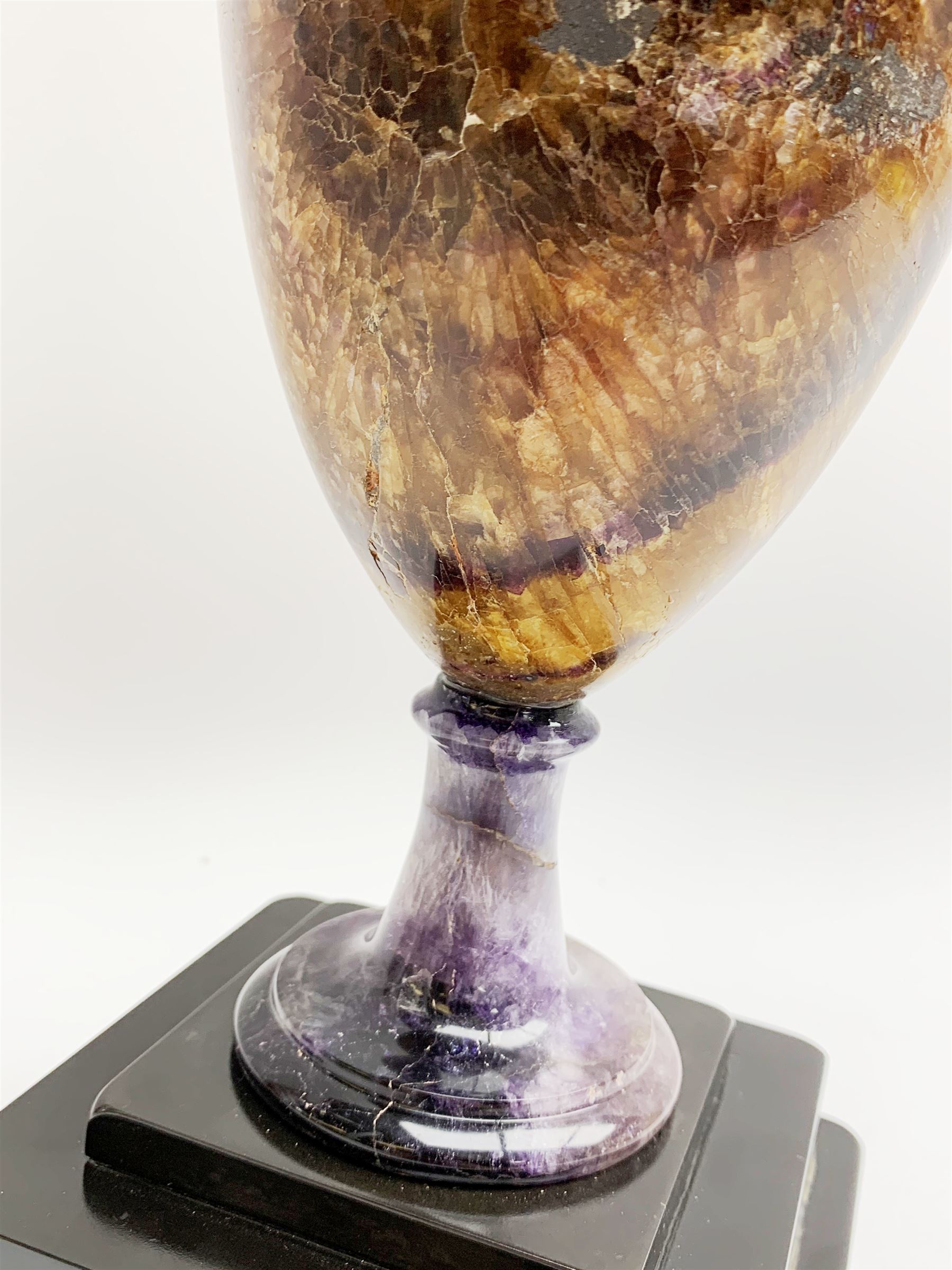 Early 19th century and later Blue John urn, Winnats one vein, of ovoid form with integrated cover and ball finial, upon a spreading circular base, and square stepped black lacquered base, H34.5cm