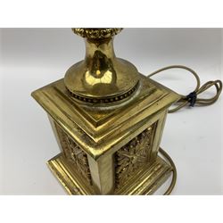Gilt metal urn shaped lamp on stepped plinth base set with stylised foliate mounts, with fabric shade with tassel detail, without shade H70.5cm
