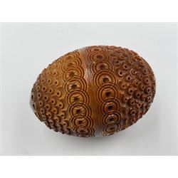 Three 19th century coquilla nut pomanders or flea catchers, two of egg shaped form and the third of barrel from with carved and pierced decoration and screw threaded join, largest H8cm