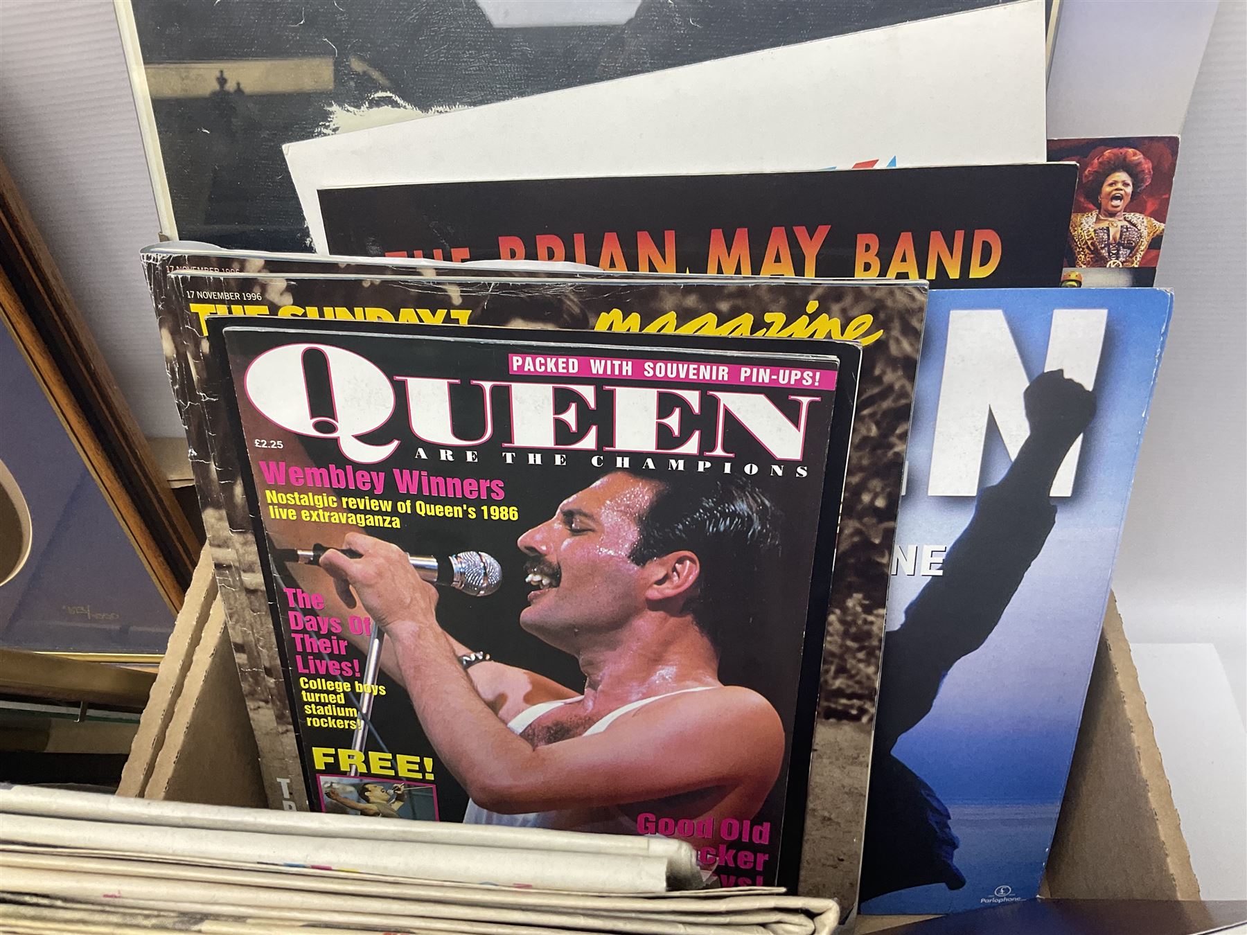 Mostly Queen and Freddie Mercury interest items, including pin badges, newspaper cuttings, diecast 'promotional' vehicles, special edition Pop Rocks figure of Freddie Mercury, VHS tapes, two charity certificates signed by Brian May and Roger Taylor, poster etc, in two boxes 