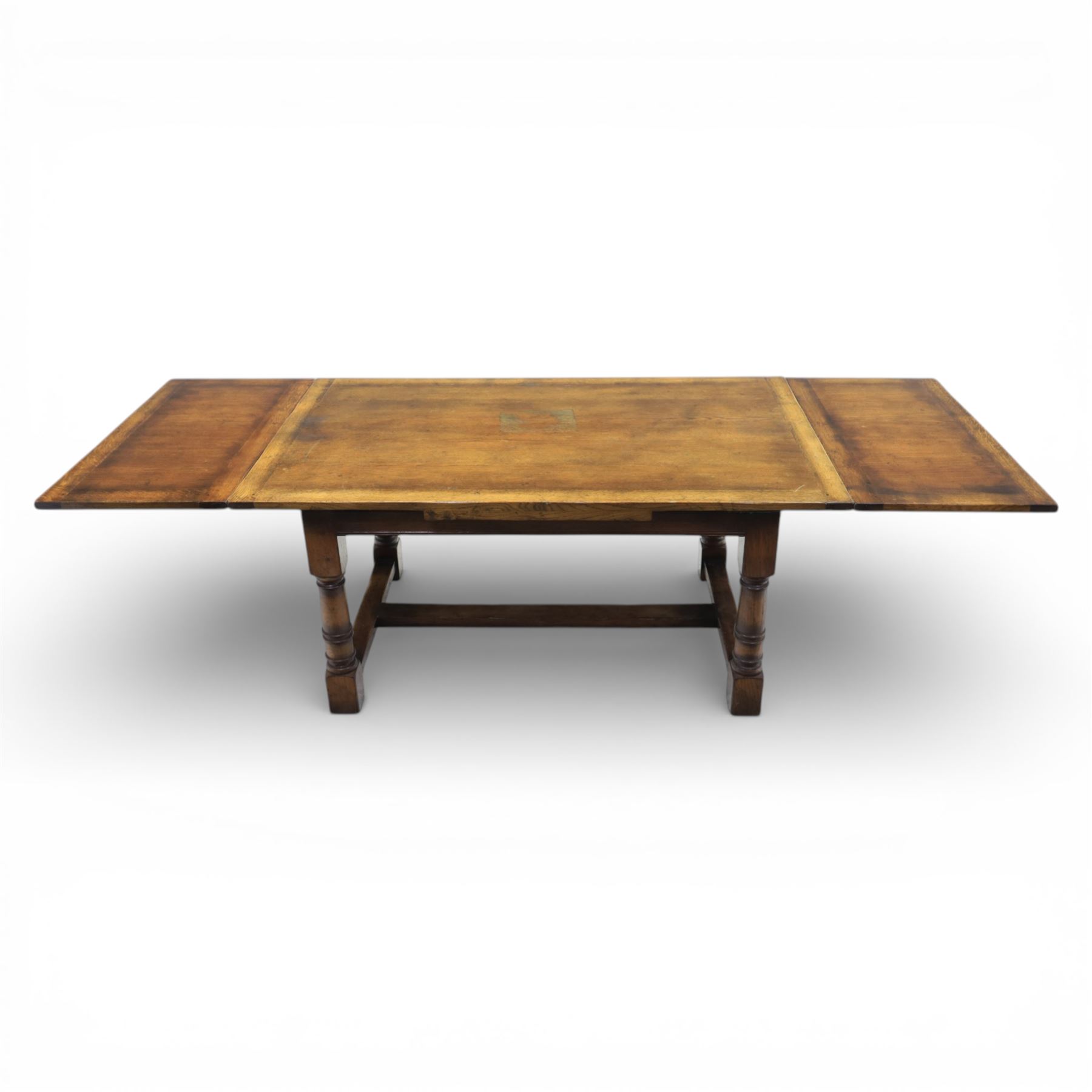 Titchmarsh & Goodwin - stained oak draw leaf dining table, raised on turned supports with H-stretcher, extends to 273cm