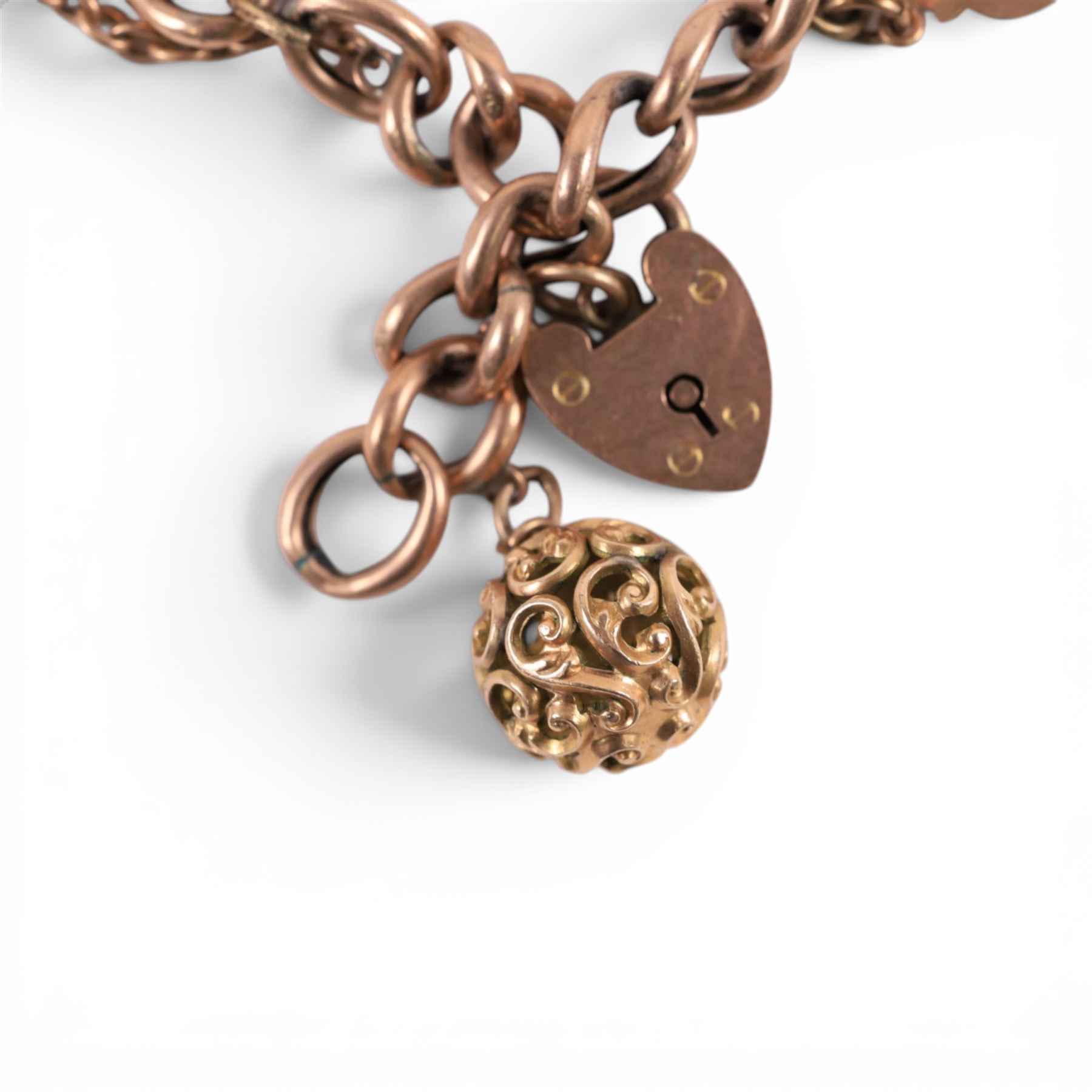 9ct gold curb link bracelet with heart padlock clasp, hallmarked, with gold imp and orb charm and two gilt charms
