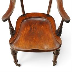 19th century carved mahogany Captain's desk chair, the bow-shaped cresting rail over curved back and turned arm supports, shaped saddle seat raised on turned supports united by crinoline stretcher, with brass cups and ceramic castors