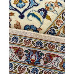 Persian Kashan ivory ground carpet, the interlaced foliate medallion surrounded by trailing plant motifs interlaced with scrolls, the guarded border with repeating stylised flower heads