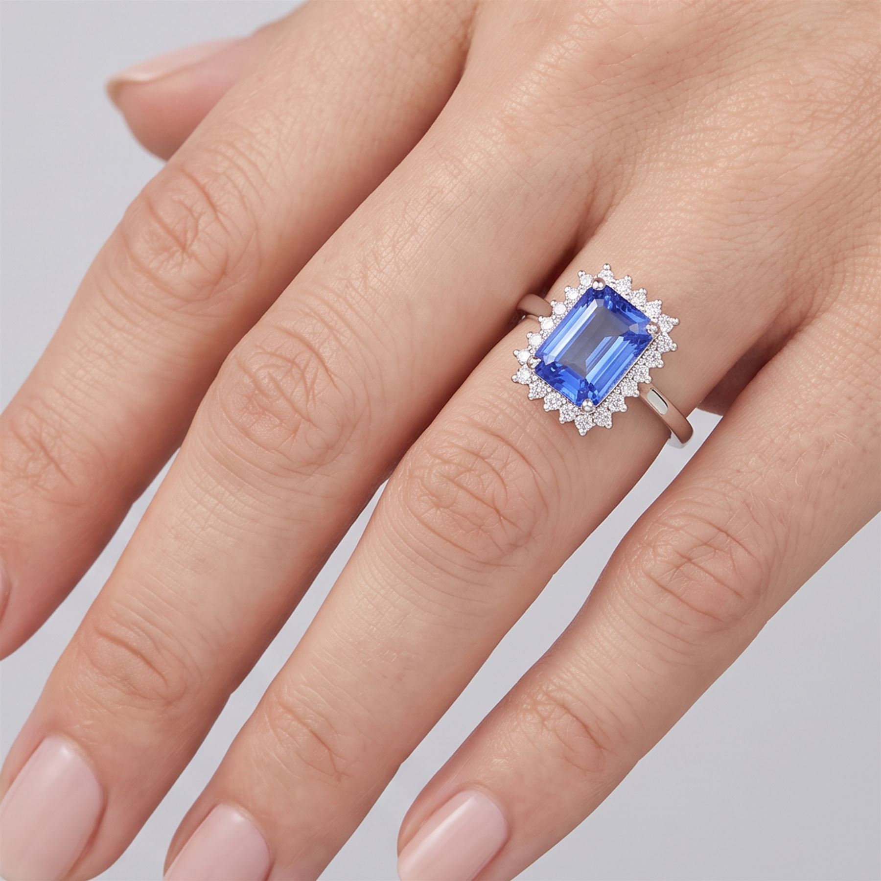 18ct white gold tanzanite and diamond cluster ring, single octagonal cut tanzanite of approx 0.80, surrounded by twenty-two round brilliant cut diamonds, stamped, total diamond weight approx 0.25 carat