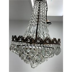 An early 20th century waterfall chandelier, the brassed mounts hung with rectangular, teardrop and button cut drops, overall approximately H70cm.