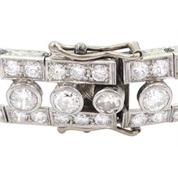 Continental Art Deco platinum old cut diamond openwork bracelet, circa 1920's, twenty-two bezel set graduating diamonds of approx 9.45 carat, the principal diamond approx 0.90, with a row milgrain set diamonds either side, the clasp set with a single diamond, the bracelet sides and clasp with engraved foliate decoration, total diamond weight approx 20.60 carat