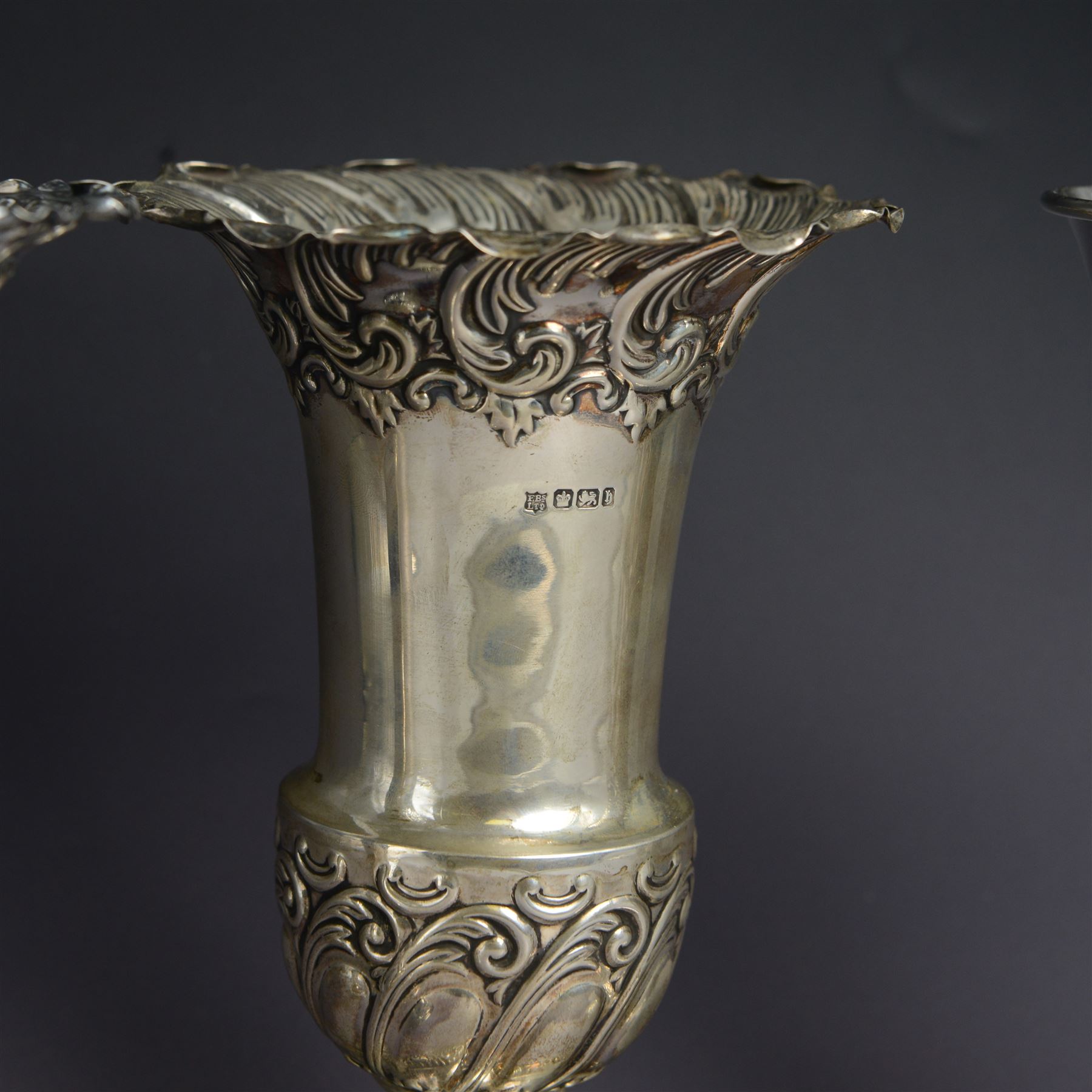 Three late 19th century/early 20th century silver vases, of trumpet form, all embossed with floral and foliate decoration, one example with weighted base, all hallmarked, tallest H18cm