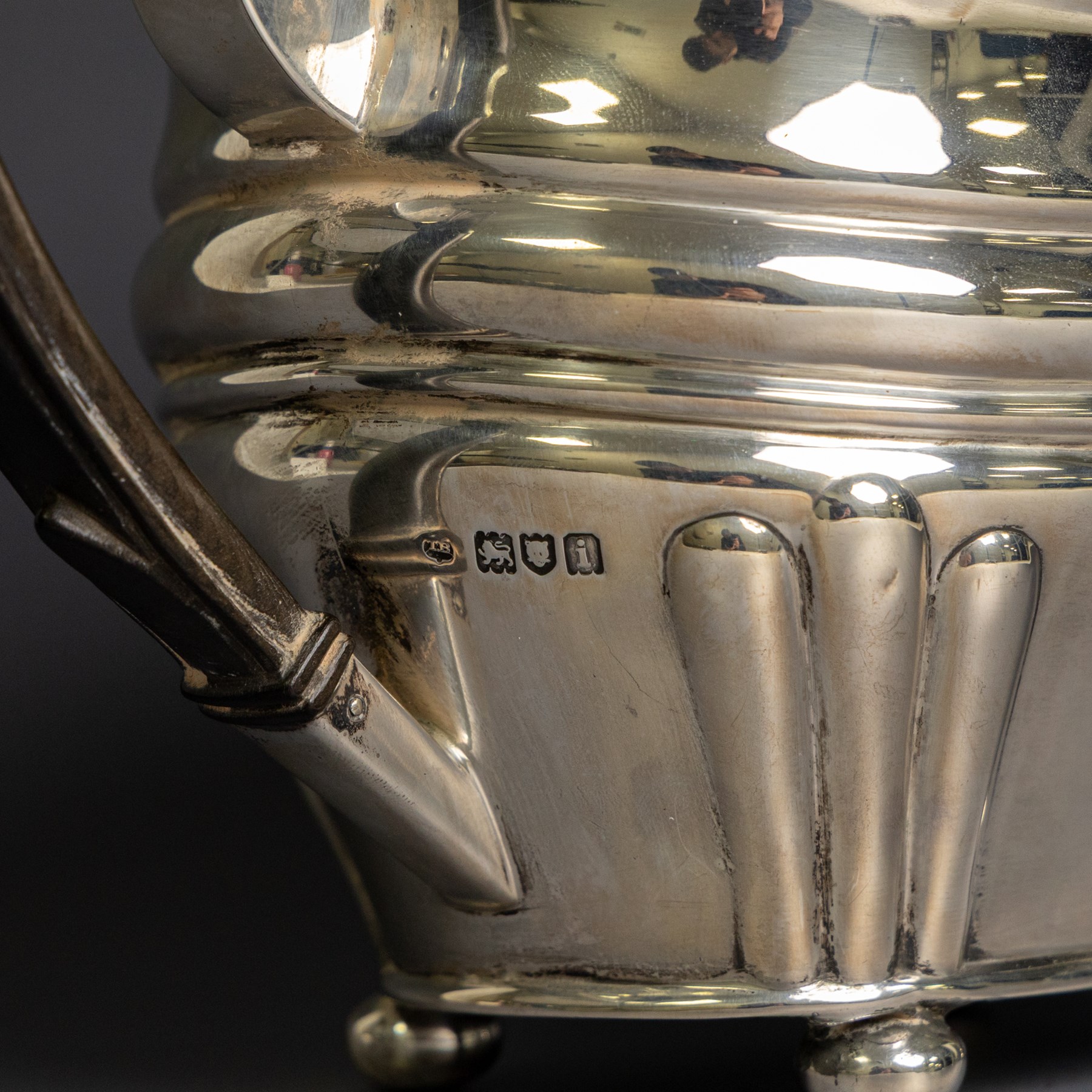 Edwardian silver teapot, of part fluted oval form upon four bun feet, with ebonised handle and finial and presentation engraving to body, hallmarked Thomas Bradbury & Sons, London 1904, H17cm