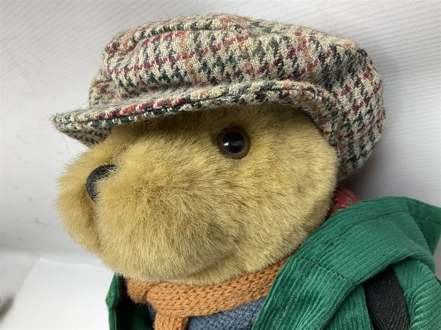 Lakeland Bears teddy bear, titled 'Walkright', dressed as a hiker in green corduroy duffle coat over fair isle jumper, trousers and knit socks, complete with leather clogs with wood soles, walkers thumb stick, knitted scarf, flat cap and rucksack housing original tag and map, H50cm